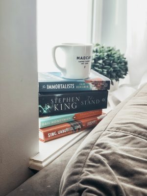 image of a stack of four books with a coffee cup