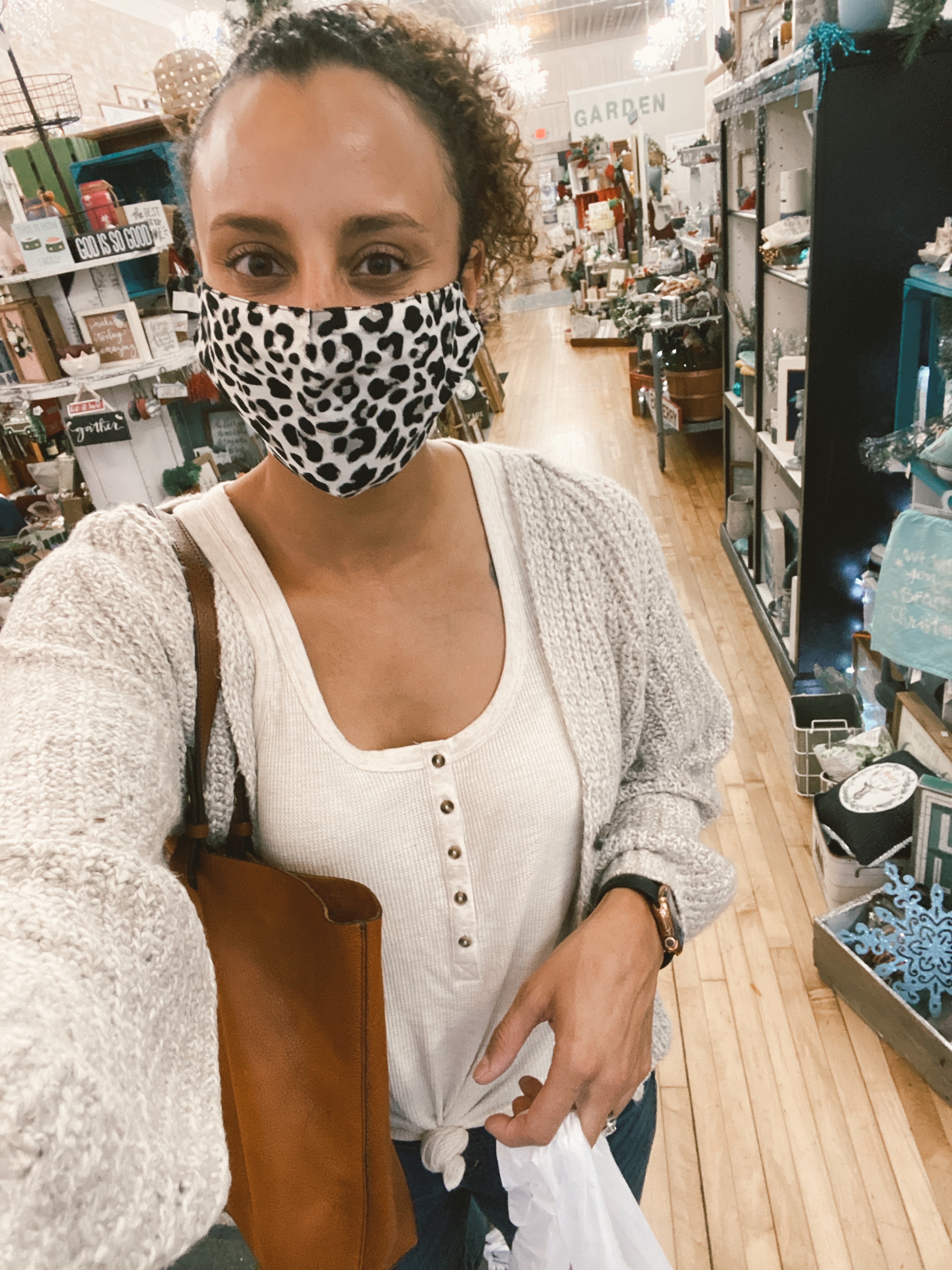 mixed race woman wearing a leopard print mask inside of a store